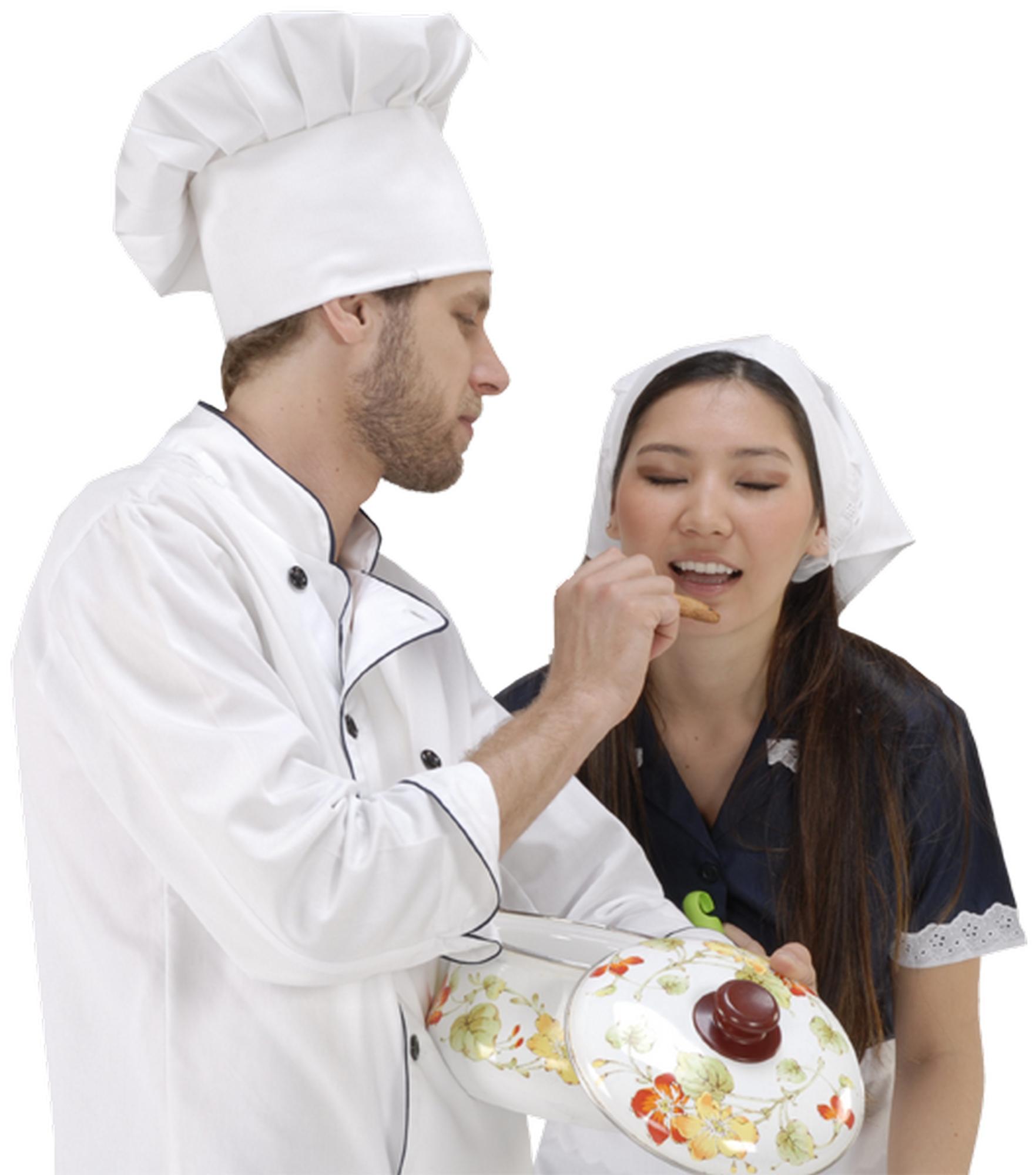 Mentor and student tasting dish in kitchen